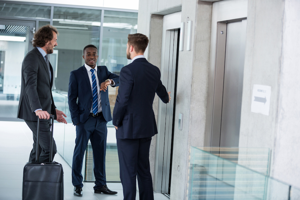 Businessmen Talking While Waiting For Elevator