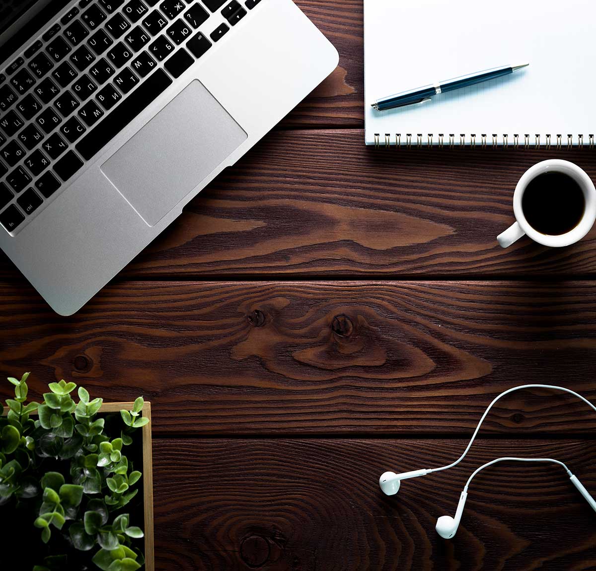 DEsk with coffee, laptop, and headphones